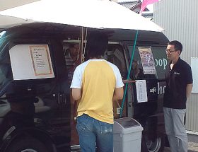 移動販売車の前で引換券とクレープを交換するお客様の様子