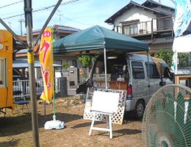 駐車場に移動販売車を停めてクレープを販売している様子