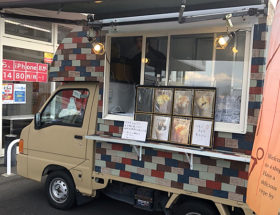 店舗の入り口横に駐車したクレープの移動販売車