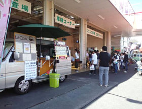 自動車ディーラーの敷地内に駐車したクレープの移動販売車